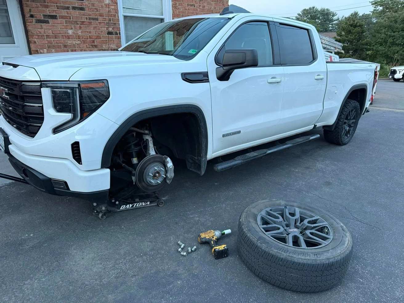 Camioneta GMC con la rueda desmontada durante un servicio de llantas a domicilio